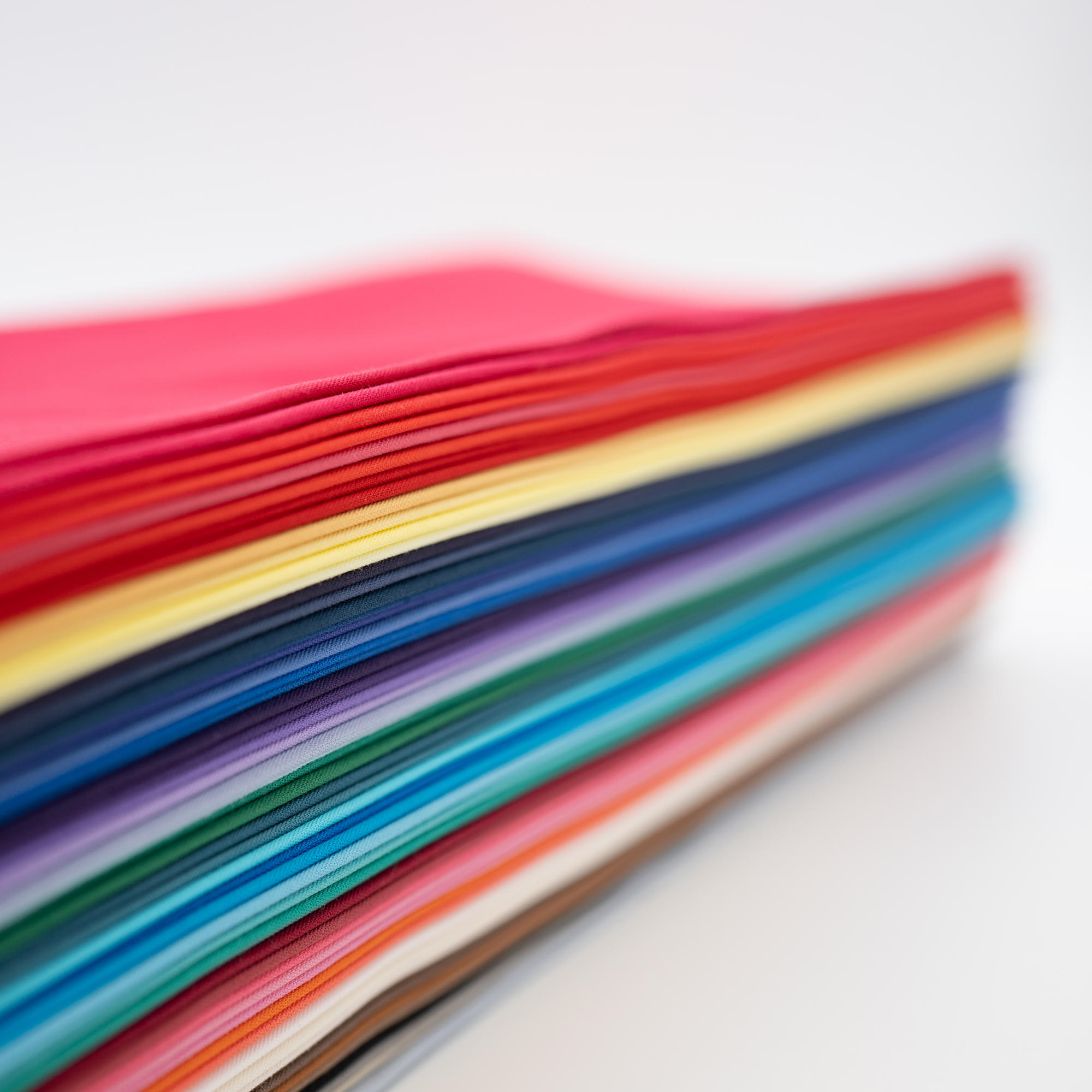 A neat stack of bundle of 60 of direct colour drapes, diagonal lengthways