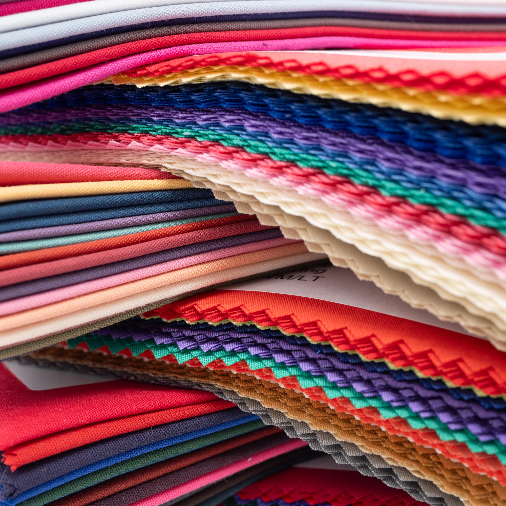 Crossways stack of all colours of direct colour drapes, close up